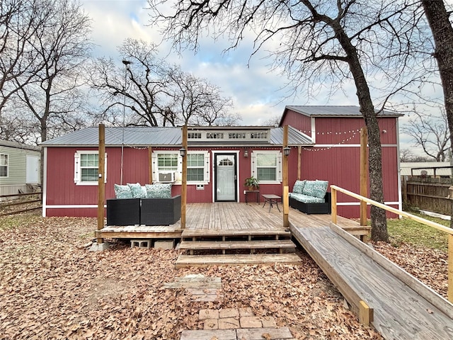 back of property with an outdoor living space and a deck