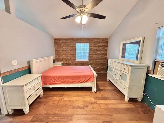 bedroom featuring light wood-type flooring, vaulted ceiling, ceiling fan, and brick wall