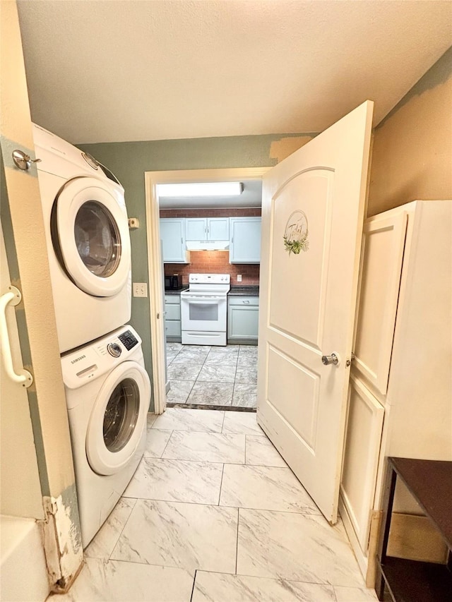 clothes washing area with stacked washer / dryer