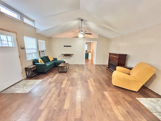 living room featuring a tiled fireplace, ceiling fan, light hardwood / wood-style floors, and lofted ceiling