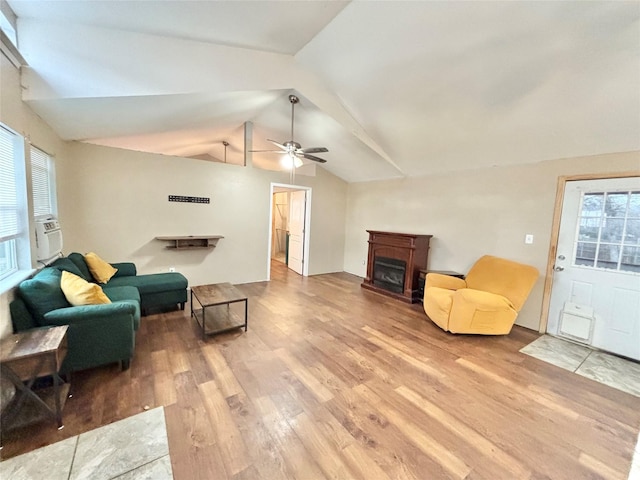 living room with ceiling fan, wood-type flooring, a wealth of natural light, and vaulted ceiling