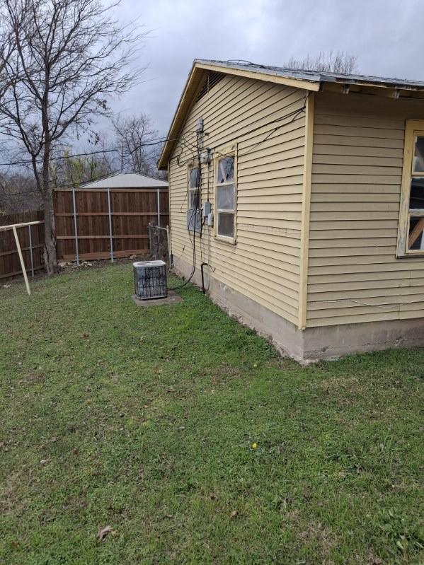 view of property exterior with a lawn and cooling unit