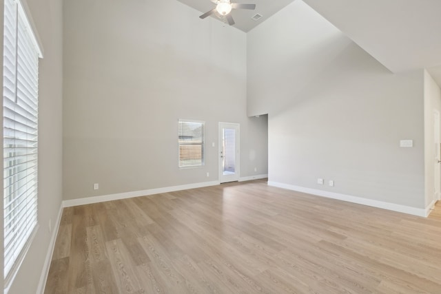 unfurnished living room with light hardwood / wood-style floors, a high ceiling, and ceiling fan