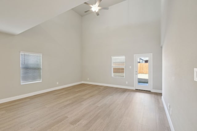 unfurnished living room featuring high vaulted ceiling, ceiling fan, and light wood-type flooring