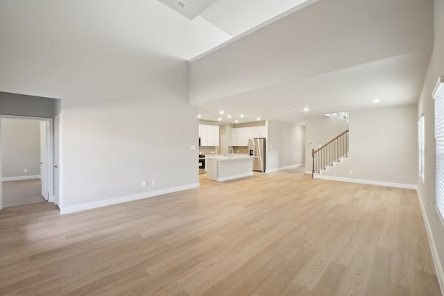 unfurnished living room with light hardwood / wood-style floors and sink