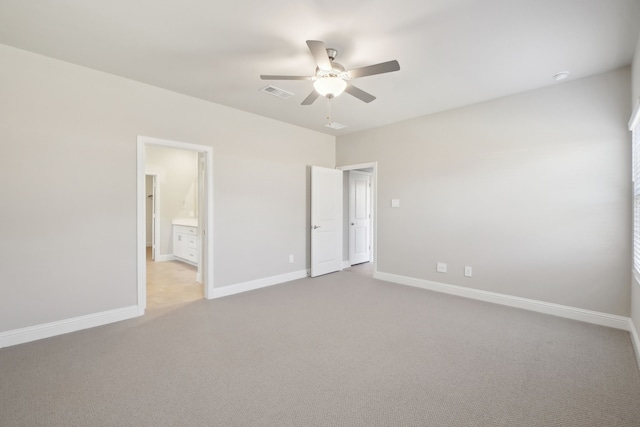 unfurnished bedroom featuring ceiling fan, light colored carpet, and connected bathroom