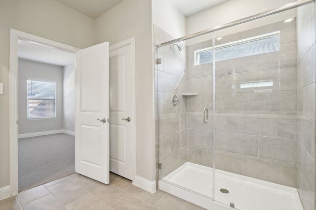 bathroom with tile patterned floors and a shower with door