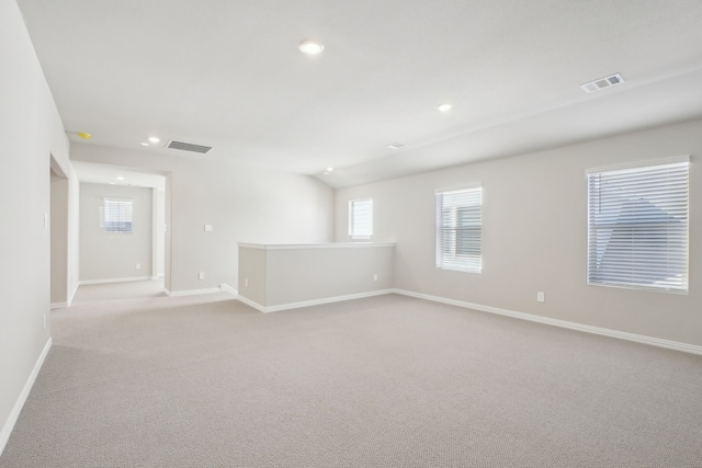 spare room with light carpet and lofted ceiling