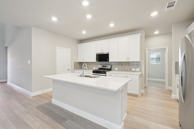 kitchen with sink, white cabinetry, a center island with sink, and stainless steel appliances