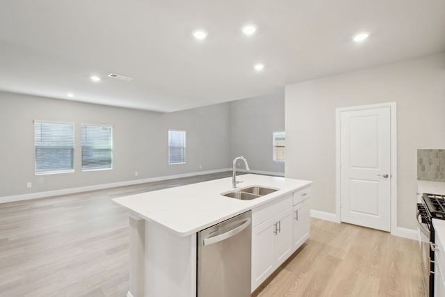 kitchen with white cabinetry, a center island with sink, appliances with stainless steel finishes, light wood-type flooring, and sink