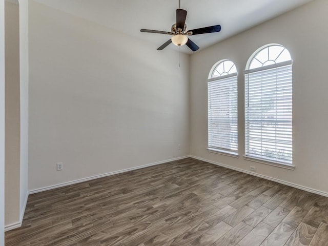 empty room with dark hardwood / wood-style flooring, ceiling fan, and plenty of natural light