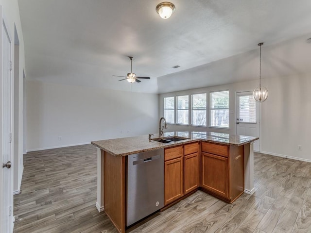 kitchen featuring ceiling fan with notable chandelier, stainless steel dishwasher, a kitchen island with sink, and sink