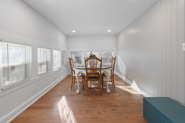 dining room featuring hardwood / wood-style floors and wooden walls