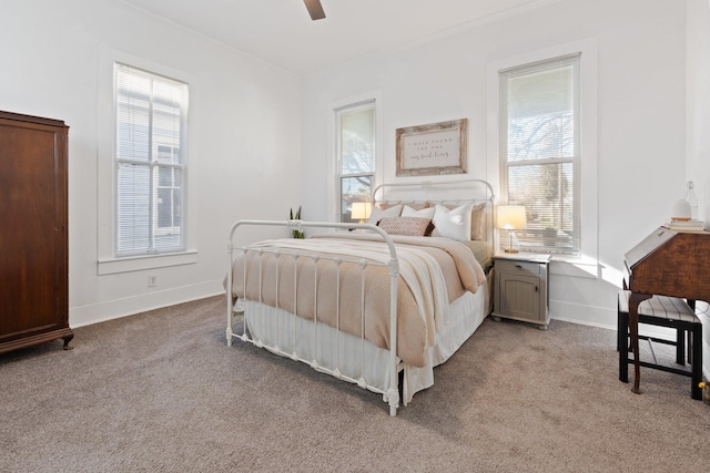 bedroom with multiple windows, ceiling fan, and light carpet