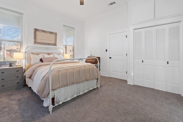 carpeted bedroom featuring ceiling fan and a closet