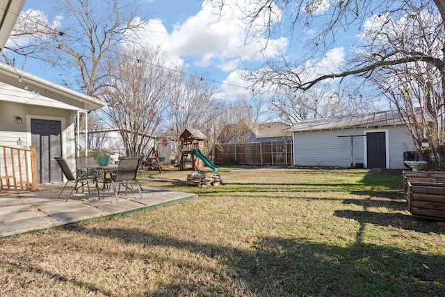 view of yard with a playground, a patio area, and an outdoor structure