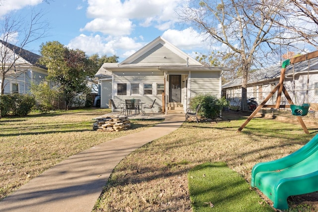 bungalow with a patio area, a playground, and a front lawn