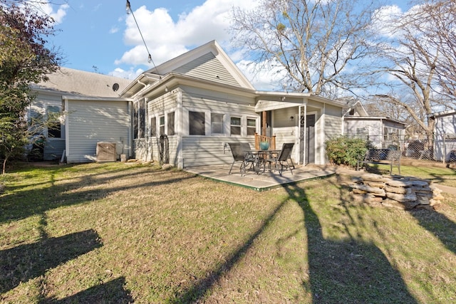 rear view of property featuring a patio and a lawn