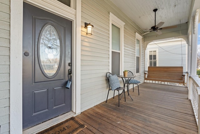 entrance to property featuring ceiling fan and a porch