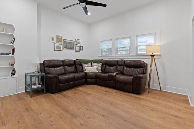 living room with ceiling fan, light hardwood / wood-style floors, and built in shelves