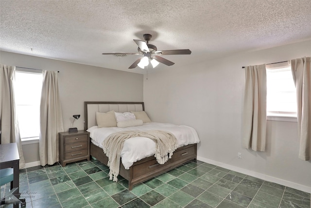 bedroom with a textured ceiling and ceiling fan