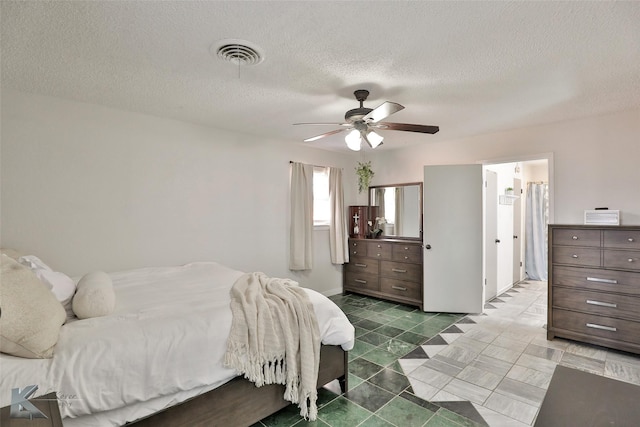 bedroom with ceiling fan and a textured ceiling