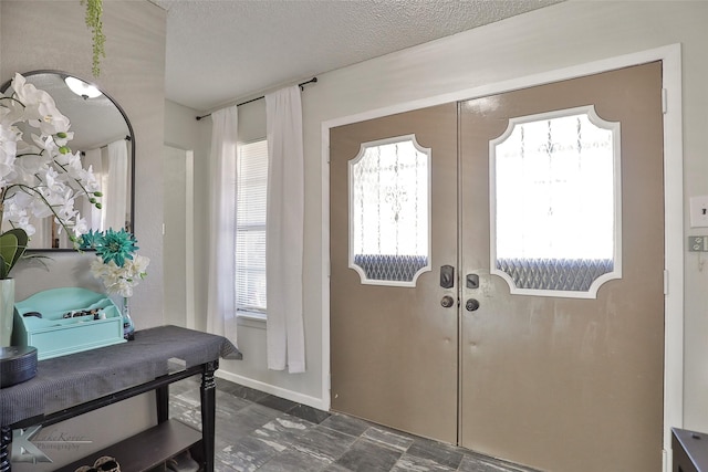 doorway featuring french doors, a healthy amount of sunlight, and a textured ceiling