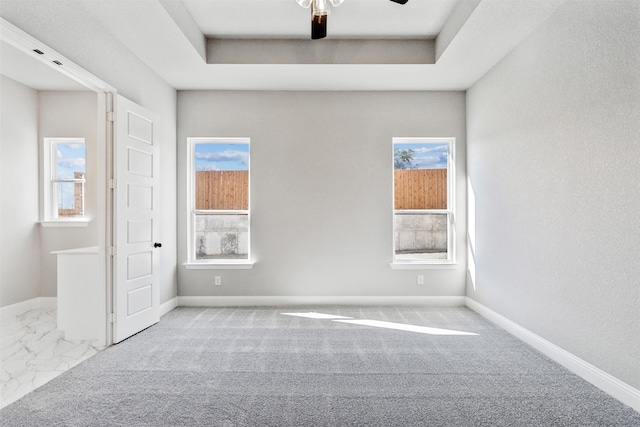 empty room with a tray ceiling and ceiling fan