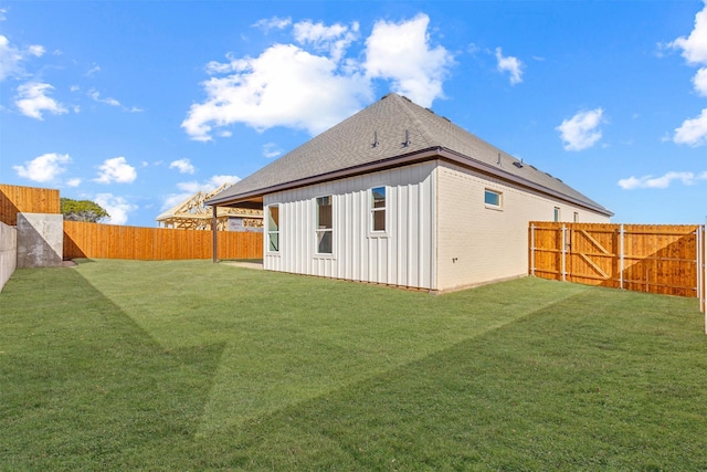 rear view of property featuring a yard