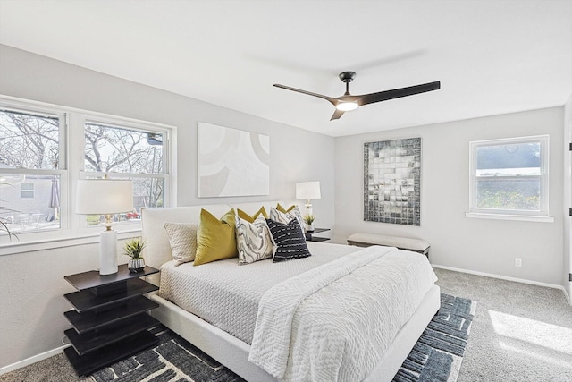 bedroom with ceiling fan, carpet floors, and multiple windows