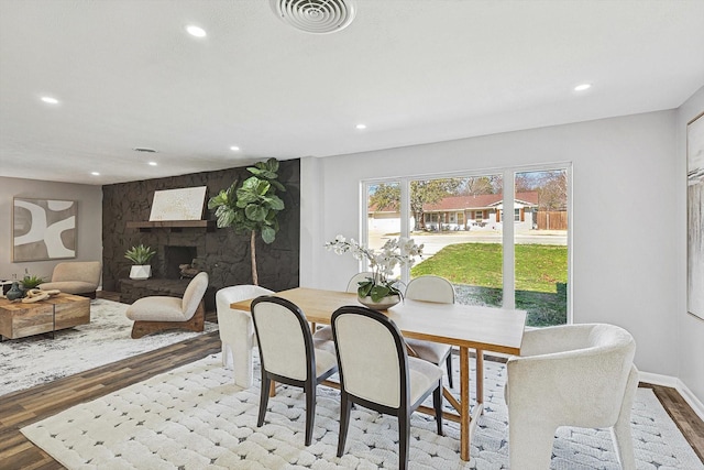 dining room featuring a fireplace and hardwood / wood-style flooring