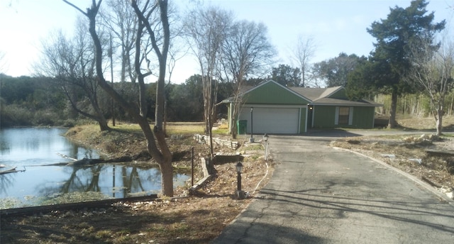 view of front of home with a garage and a water view