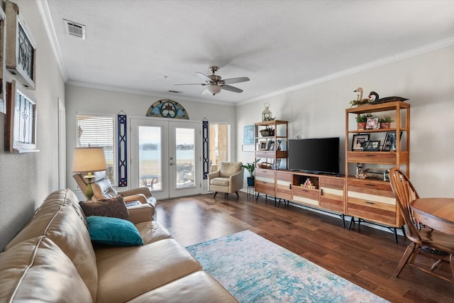 living room featuring french doors, ornamental molding, a textured ceiling, ceiling fan, and dark wood-type flooring