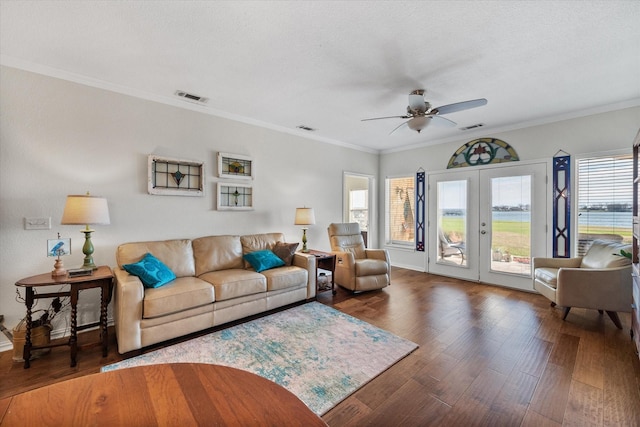 living room featuring french doors, ceiling fan, ornamental molding, a textured ceiling, and dark hardwood / wood-style flooring