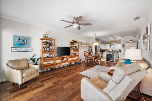 living room with crown molding, ceiling fan, and dark wood-type flooring