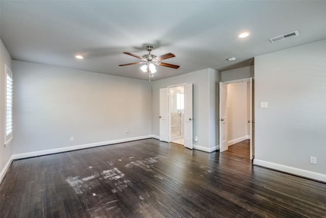 empty room featuring visible vents, wood finished floors, baseboards, and ceiling fan