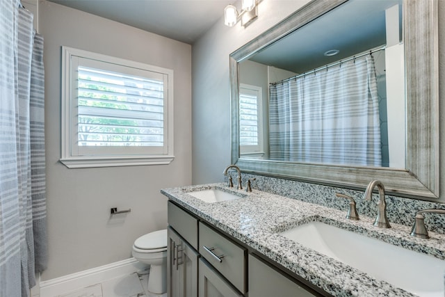 full bath with toilet, a sink, and a wealth of natural light