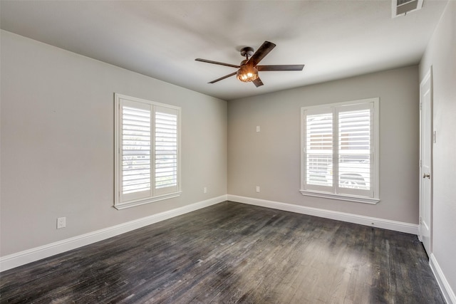 empty room with dark wood-style floors, baseboards, and ceiling fan