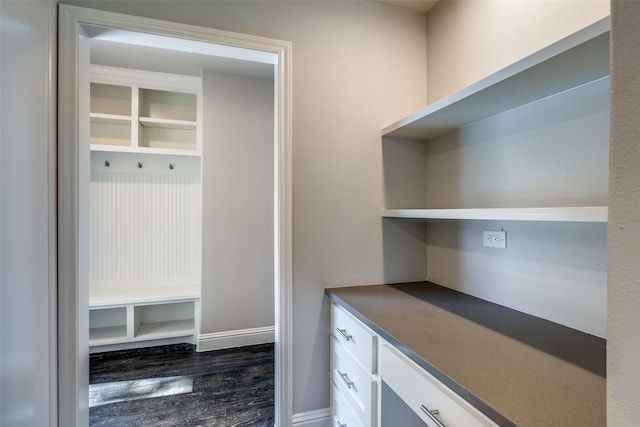 mudroom with dark wood finished floors and baseboards