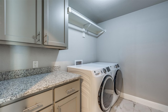 laundry room with independent washer and dryer, cabinet space, marble finish floor, and baseboards