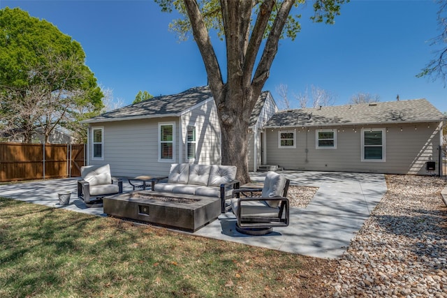 rear view of property featuring an outdoor living space with a fire pit, a patio area, fence, and a lawn