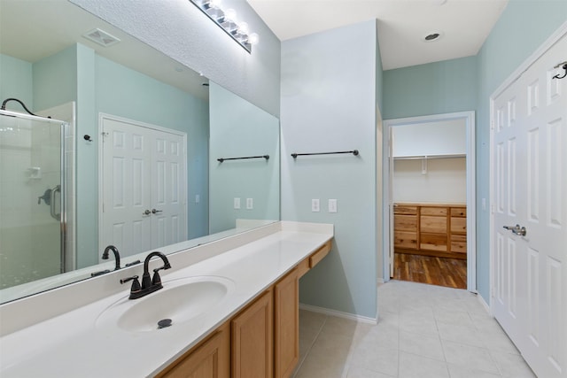 bathroom with vanity, a shower with shower door, and tile patterned floors