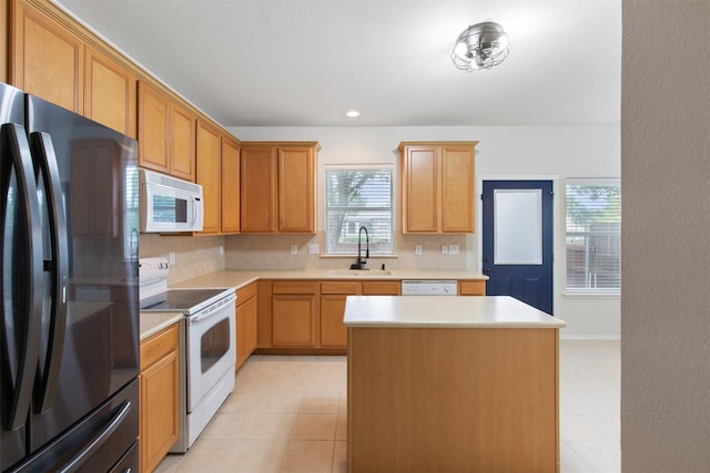 kitchen featuring sink, white appliances, backsplash, a center island, and light tile patterned flooring