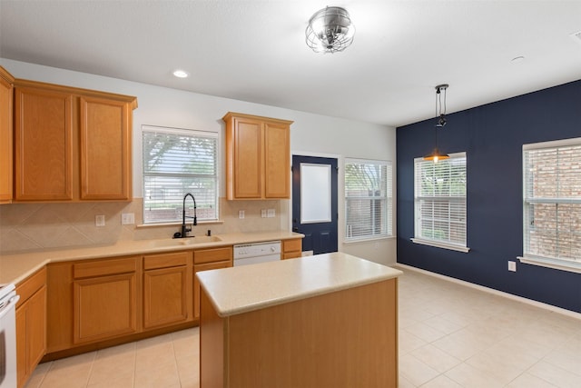 kitchen featuring sink, hanging light fixtures, a center island, white dishwasher, and tasteful backsplash