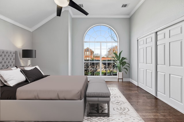 bedroom featuring ceiling fan, dark hardwood / wood-style flooring, crown molding, and a closet