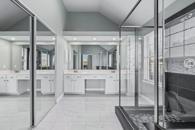 bathroom featuring vanity, a healthy amount of sunlight, a shower with shower door, and vaulted ceiling