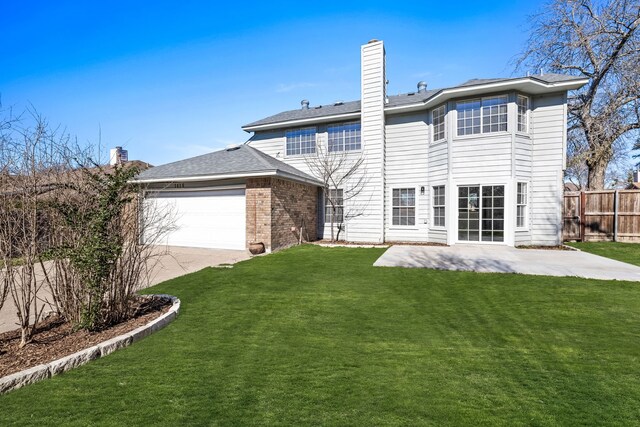 back of property with a lawn, a patio area, and a garage