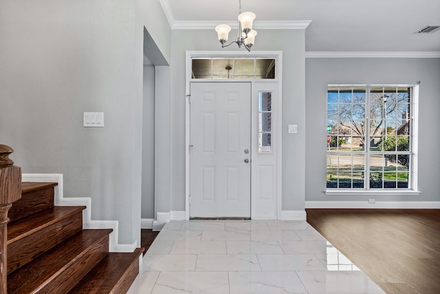 foyer entrance with light hardwood / wood-style floors, a chandelier, and ornamental molding