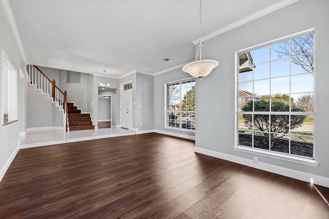 unfurnished living room with crown molding, dark hardwood / wood-style floors, and a notable chandelier