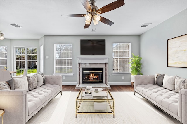 living room with a tile fireplace, ceiling fan, and hardwood / wood-style flooring